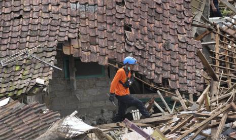 Seorang penyelamat berjalan di antara puing-puing saat mencari korban di sebuah desa yang dilanda tanah longsor akibat gempa di Cianjur, Jawa Barat, Indonesia, Kamis, 24 November 2022. Pada hari keempat pencarian yang semakin mendesak, penyelamat Indonesia mempersempit bekerja Kamis hingga tanah longsor di mana puluhan diyakini terperangkap setelah gempa bumi yang menewaskan ratusan orang, banyak dari mereka anak-anak. 