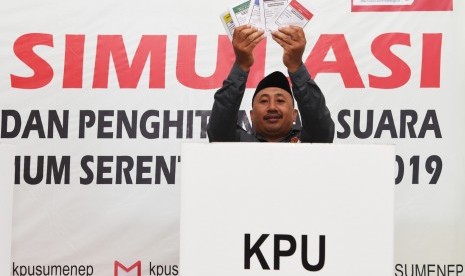 Seorang penyelenggara Pemilu 2019 menunjukan kertas suara sebelum melakukan pencoblosan di bilik suara saat simulasi pemungutan dan perhitungan suara pemilihan umum 2019 di Sumenep, Jawa Timur, Sabtu (16/3/2019).