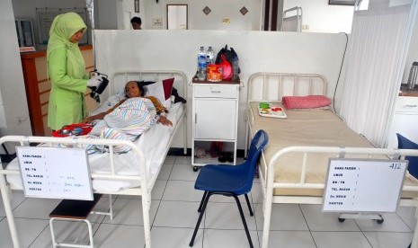 Seorang perawat tengah memeriksa seorang pasien yang kurang mampu di Rumah Sehat Masjid Agung Sunda Kelapa, jakarta, Senin (2/4). (Republika/Agung Supriyanto)