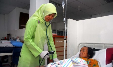 Seorang perawat tengah memeriksa seorang pasien yang kurang mampu di Rumah Sehat Masjid Agung Sunda Kelapa, jakarta, Senin (2/4). (Republika/Agung Supriyanto)