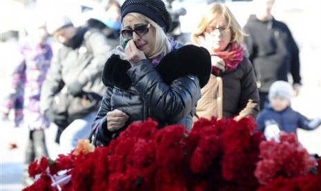 Seorang perempuan berduka setelah meletakkan bunga untuk menghormati korban jatuhnya pesawat FlyDubai di Bandara Rostov-on-Don di Moskow, Rusia, Ahad, 20 Maret 2016.