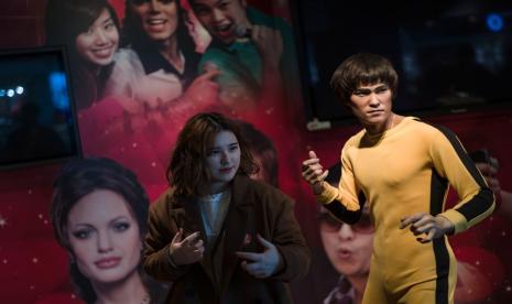 Seorang perempuan berpose di sebelah patung lilin aktor laga legendaris Bruce Lee di Madame Tussauds Hong Kong, 30 Januari 2018. Menulis di jurnal Clinical Kidney Journal, tim dokter mengungkap minum air putih terlalu banyak kemungkinan menjadi penyebab kematian Bruce Lee.