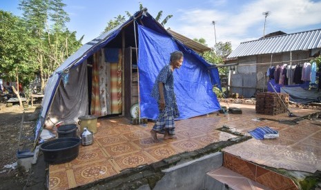 Seorang perempuan korban gempa berada dekat tenda yang dibangun diatas bekas rumahnya yang roboh akibat gempa di Desa Dopang, Kecamatan Gunungsari, Lombok Barat, NTB, Selasa (26/3/2019). 