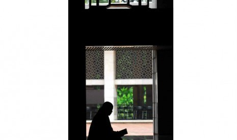 Seorang perempuan membaca kitab suci Alquran usai melaksanakan ibadah Shalat Dzuhur di Masjid Istiqlal, Jakarta, Senin (23/7). (Agung Supriyanto/Republika)