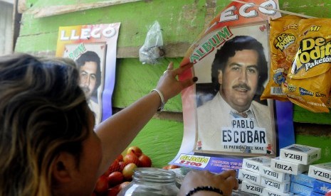 Seorang perempuan mencopot foto Pablo Escobar dari dinding di Kota Medelin, Kolombia, pada 2012.