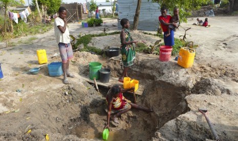 Seorang perempuan mengambil air dari sumber yang tidak terlindungi di Beira, Mozambik, Ahad (31/3). Kasus kolera melonjak di Mozambik usai badai Idai melanda. v