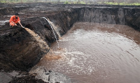 Seorang personel Manggala Agni mengalirkan air ke dalam embung di lahan bekas kebakaran di Desa Rimbo Panjang Kabupaten Kampar, Riau, Jumat (9/10). 