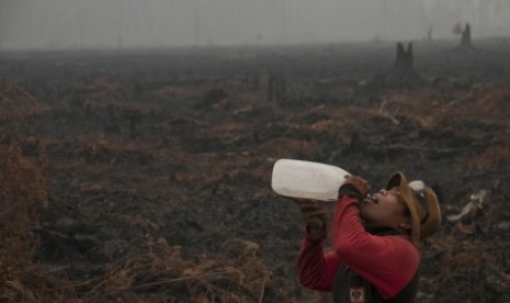 Seorang personel pemadam kebakaran Manggala Agni beristirahat saat melakukan pemadaman kebakaran di hutan Kawasan Suaka Margasatwa Kerumutan, Kabupaten Pelalawan, Riau, Rabu (28/10).