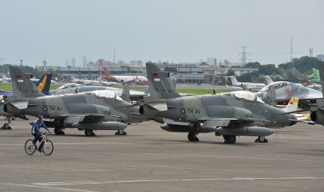 Seorang personel TNI AU mengayuh sepeda di dekat sejumlah pesawat jet tempur yang terparkir di Terminal Selatan seusai terbang mengikuti gladi bersih Upacara Peringatan ke-71 Hari TNI AU tahun 2017 di Lanud Halim Perdanakusuma, Jakarta, Jumat (7/4).