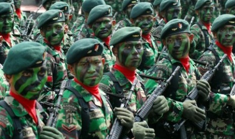 Seorang personil TNI AD menjelaskan peralatan persenjataan kepada sejumlah siswa saat sebuah pameran Alat Utama Sistem Persenjataan (Alutsista) TNI.