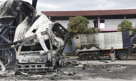 Seorang perwira Thailand berdiri di samping kapal tanker minyak yang terbakar di sebuah pompa bensin di provinsi Pattani, Thailand selatan, Rabu, 17 Agustus 2022. Gelombang pembakaran dan serangan bom semalam melanda provinsi paling selatan Thailand, yang selama hampir dua dekade telah menjadi tempat pemberontakan separatis Muslim yang aktif, kata para pejabat Rabu.