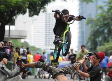 Seorang pesepeda melakukan atraksi dengan sepeda bmx saat Hari Bebas Kendaraan Bermotor di Kawasan Sudirman, Jakarta, Ahad (11/3). (Republika/Wihdan Hidayat)