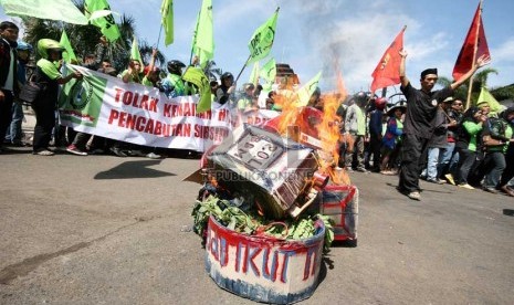  Seorang peserta aksi dari Serikat Buruh Sejahtera Indonesia (SBSI) membakar replika drum dan jerigen bahan BBM dalam aksi  menolak kenaikan BBM di depan Gedung Sate, Bandung, Kamis (23/5).     (Republika/Edi Yusuf)