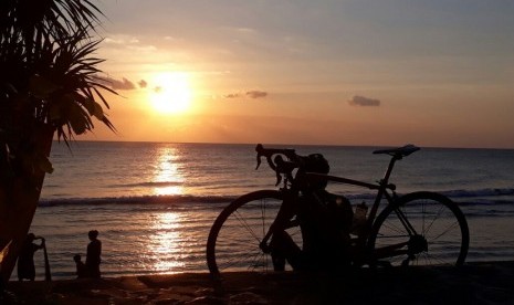 Seorang peserta Grand Fondo New York (GFNY) sedang menikmati matahari terbenam di Pantai Senggigi pada Sabtu (2/9). Dijadwalkan, 800 pembalap, baik dalam dan luar negeri akan mengikuti gowes lintas alam sepanjang 160 Km di Lombok, Nusa Tenggara Barat (NTB) pada Ahad (3/9).