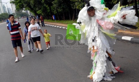 Seorang peserta kampanye memberikan sosialisasi pengurangan sampah kantong plastik kepada warga yang melintas di Jalan Jenderal Sudirman, Jakarta, Ahad (24/2).  (Republika/Agung Fatma Putra)