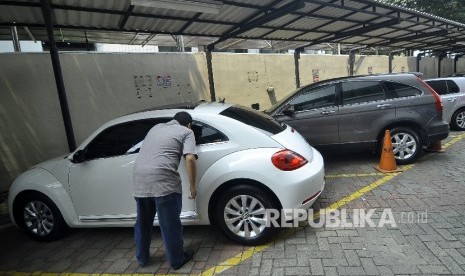  Seorang peserta lelang mengamati mobil sitaan KPK hasil tindak pidana korupsi di Gedung KPK lama, Jakarta, Selasa (19/9). 