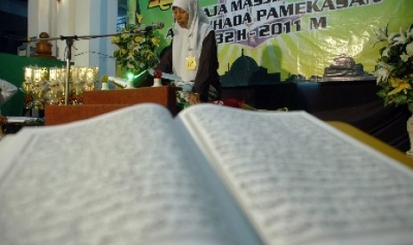 Seorang peserta membaca Alquran, saat berlangsung lomba Musabaqoh Tilawatil Quran (MTQ) tingkat remaja. 