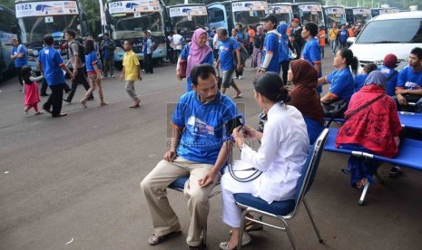   Seorang peserta mudik gratis memeriksa tensi darahnya di posko kesehatan di Gelora Bung Karno, Jakarta, Kamis (24/7). (Republika/Agung Supriyanto)