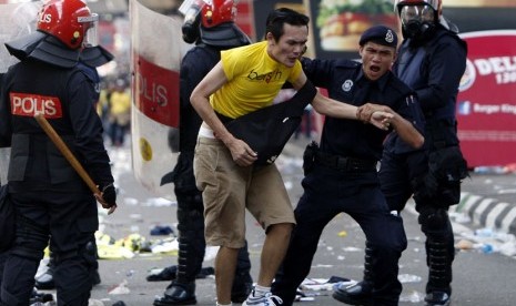   Seorang peseta aksi unjuk rasa ditahan oleh polisi di Kuala Lumpur, Malaysia, Sabtu (28/4).  (Mark Baker/AP)