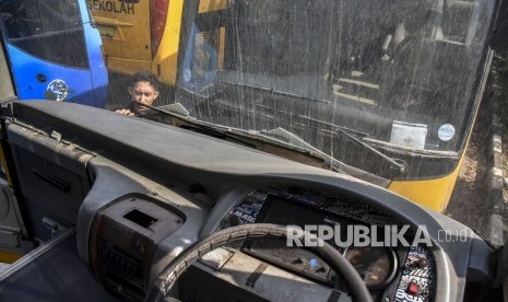 Seorang petugas beraktivitas di antara bus sekolah yang terparkir di Balai Pengujian Kendaraan Dinas Perhubungan, Gedebage, Kota Bandung, Rabu (16/10). Sebanyak tujuh unit bus sekolah mulai beroperasi di masa pembelajaran tatap muka (PTM) terbatas di masa pandemi Covid-19 yang digelar hari ini, Rabu (8/9).