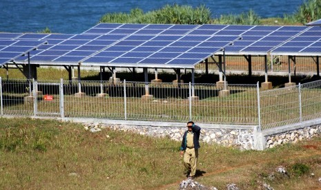 Seorang petugas berjalan di dekat pembangkit listrik tenaga surya di Balong Technopark, Kawasan Pantai Baron, Gunungkidul, Yogyakarta, Selasa (5/6).