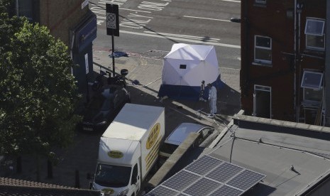 Seorang petugas forensik sedang memeriksa sebuah mobil van di dekat stasiun Finsbury Park setelah kendaraan tersebut menghantam pejalan kaki di London utara, Senin (19/6).