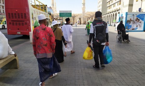 Seorang petugas haji membawakan barang belanjaan jamaah menuju pemondokannya di Madinah, Selasa (16/7). Di sela-sela waktu menanti shalat, sebagian jamaah memanfaatkannya untuk berbelanja di pasar dekat Masjid Nabawi. 