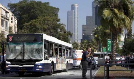 Seorang petugas keamanan Israel berdiri di samping bus di lokasi serangan bom di Tel Aviv,Israel,Rabu (21/11).