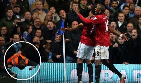 Seorang petugas keamanan (lingkaran) terjatuh saat fans Chelsea berang atas selebrasi striker MU Javier Hernandes