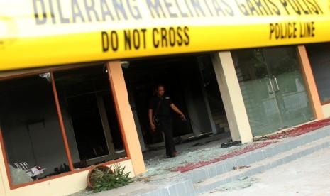 Seorang petugas kepolisian berada di lokasi bekas kebakaran kantor DPRD Kabupaten Gowa, Sulawesi Selatan, Selasa (27/9). 