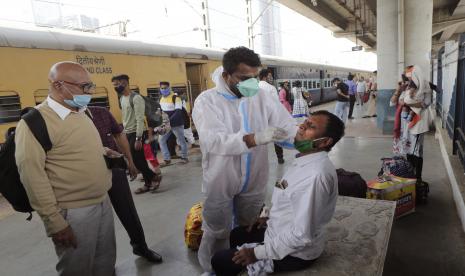  Seorang petugas kesehatan mengambil sampel usap seorang komuter untuk menguji COVID-19 di sebuah stasiun kereta di Mumbai, India, Kamis, 11 Februari 2021. 