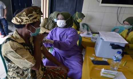 Seorang petugas kesehatan menyuntikan vaksin COVID-19 kepada seoarang warga, di Pure Banjar Buana Sakti, Labuhan Dalam, Bandar Lampung, Lampung, Selasa (7/9/2021). Staf Khusus Kepresidenan dan Polri melakukan vaksinasi serentak untuk warga di Pesantren dan tempat Ibadah di seluruh wilayah Indonesia guna untuk mencapai kekebalan komunal atau herd immunity terhadap masyarakat untuk menuju Indonesia sehat bebas COVID-19.