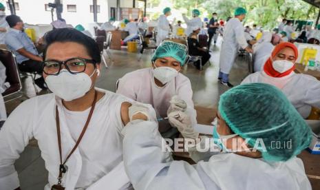 Seorang petugas kesehatan menyuntikkan satu dosis vaksin COVID-19 Sinovac ke pasien saat vaksinasi massal untuk dosen universitas di Medan, Sumatera Utara, Senin (29/3).