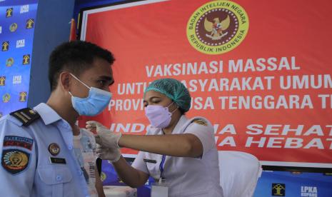 Seorang petugas Lapas anak Kupang menerima suntikan vaksin dosis ketiga atau pengguat saat pelaksanaan vaksinasi massal di Lapas Anak Kupang, NTT, Selasa (22/3/2022). BIN menggelar vaksinasi COVID-19 di Kota Kupang dengan menyasar 200 orang baik penerima dosis pertama hingga dosis pengguat dalam rangka meningkatkan Herd Immunity.