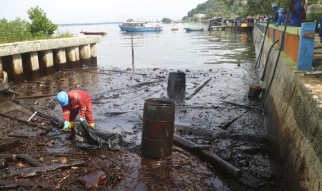 Seorang petugas melakukan pembersihan di lokasi dekat tumpahan minyak di Teluk Balikpapan, Kalimantan Timur, Rabu (4/4). 