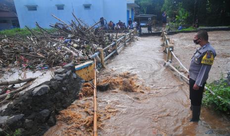 Seorang petugas melihat sampah yang menyumbat Sungai Dawe di Desa Golantepus, Mejobo, Kudus, Jawa Tengah, Kamis (14/7/2022). Menurut kepala desa setempat, akibat intensitas hujan yang tinggi serta banyaknya sampah yang menyumbat aliran Sungai Dawe tersebut menyebabkan kurang lebih 500 rumah dan jalan utama di desa itu terdampak.