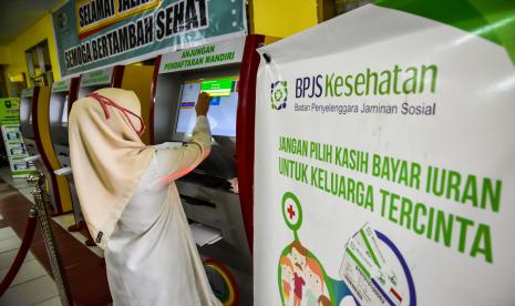 Seorang petugas membantu memasukkan data pasien pengguna BPJS Kesehatan di mesin anjungan pengantrean mandiri di RSUD Arifin Achmad, Kota Pekanbaru, Riau, Selasa (14/7/2020). Pemerintah Indonesia menanggung biaya pasien COVID-19 di rumah sakit rujukan melalui BPJS Kesehatan karena dinilai sudah biasa melakukan verifikasi klaim dari fasilitas kesehatan, sehingga mempercepat penyaluran dana penanganan COVID-19 kepada rumah sakit pada masa pandemi.