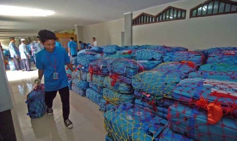 Seorang petugas membawa koper calon jamaah haji di Gedung Serba Guna asrama haji, Pondok Gede, Jakarta Timur, Ahad (31/8).(Republika/Raisan Al Farisi)