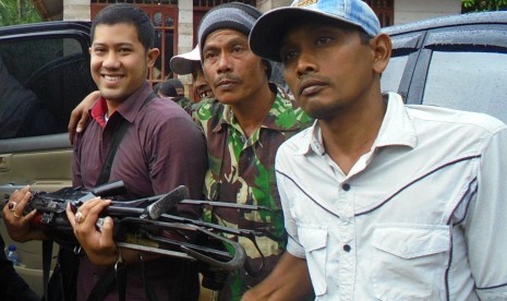 Seorang petugas membawa senjata milik kelompok Nurdin alias Din Minimi setelah diserahkan kepada pihak berwajib di Desa Ladang Baro, Kecamatan Julok, Aceh Timur, Aceh, Selasa (29/12).