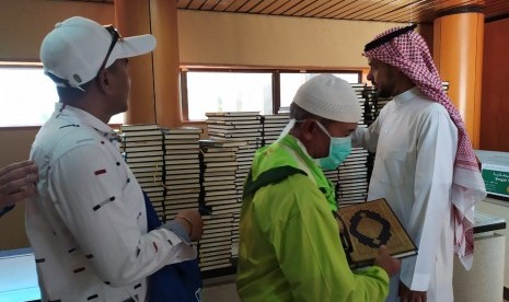 Seorang petugas memberikan Al-Quran kepada jamaah haji yang berkunjung ke Pusat Percetakan Al-Quran di Madinah, Selasa (16/7). Al-Quran dicetak di tempat ini sebanyak 18 juta eksemplar dan disebar ke 76 negara di dunia. 