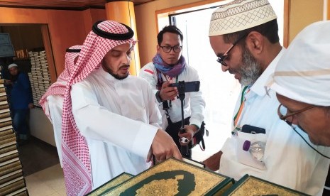 Seorang petugas memberikan Al-Quran kepada jamaah haji yang berkunjung ke Pusat Percetakan Al-Quran di Madinah, Selasa (16/7). Al-Quran dicetak di tempat ini sebanyak 18 juta eksemplar dan disebar ke 76 negara di dunia. 