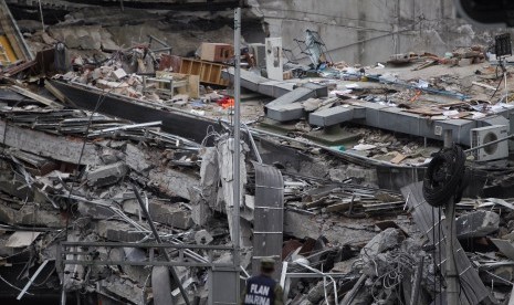 Seorang petugas mengamati tumpukan puing yang merupakan lantai bangunan sambil terus mencari korban selamat menyusul gempa 7,1 skala richter yang terjadi di Meksiko, Selasa (19/9).