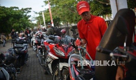 Seorang petugas mengosongkan bensin kendaraan bermotor calon pemudik sebelum memasuki KM Dobonsolo saat mudik gratis di Pelabuhan Tanjung Priok, Jakarta Utara, Senin (19/6).