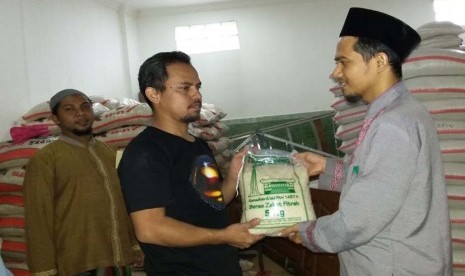 Seorang petugas Panitia Zakat Masjid Agung Sunda Kelapa (MASK) Menteng Jakarta Pusat menyerahkan beras zakat fitrah kepada seorang mustahik, Selasa (5/7).