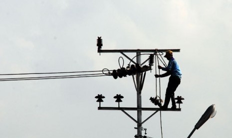 Seorang petugas PLN melakukan perbaikan instalasi jaringan listrik.