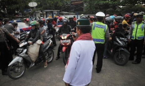 Seorang petugas Polisi Satuan Lalu Lintas mengenakan busana muslim menyampaikan dakwah kepada sejumlah pengendara motor saat Operasi Zebra Candi di kawasan Kantor Samsat Pekalongan, Jawa Tengah, Senin (26/10). 