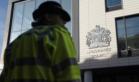 Seorang polisi berjaga di luar pengadilan Chelmsford Magistrates Court di Chelmsford, Essex, Inggris, Senin (28/10). Sopir truk Maurice Robinson (25 tahun) didakwa 39 pembunuhan dan tuduhan lain atas temuan 30 jenazah dalam truk.