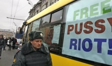 Seorang polisi berjalan melewati bus yang akan membawa kelompok demonstran punk wanita 'Pussy Riot' menggelar demonstrasi di Moskow, Rusia, Sabtu (31/3). 