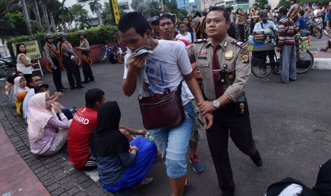 Seorang Polisi mengamankan copet yang beraksi pada hari bebas kendaraan bermotor (HBKB) di Kawasan Bundaran HI Jakarta, Minggu (15/1). 