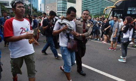 Seorang Polisi mengamankan copet yang beraksi pada hari bebas kendaraan bermotor (HBKB) di Kawasan Bundaran HI Jakarta, Minggu (15/1).